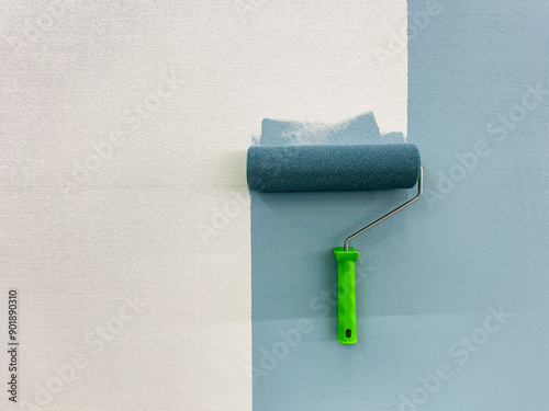 A paint roller is actively in use at this moment to efficiently apply paint onto the surface of a wall, which ensures that there is an even and seamless finish along with vibrant color hues