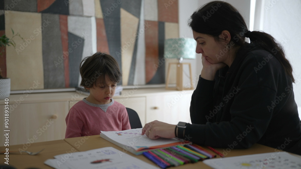 Parent and child engaged in a focused learning session, highlighting the importance of education and support at home, with the child paying close attention to the workbook