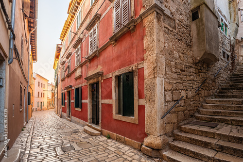 Rovinj, Croatia - Stone paved street and stairs at the Old Town of Rovinj. Traditional Croatian houses in an alleway at sunrise on a summer morning photo