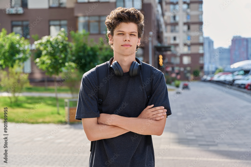 Fototapeta premium Handsome young man looking at camera outdoors, city street background