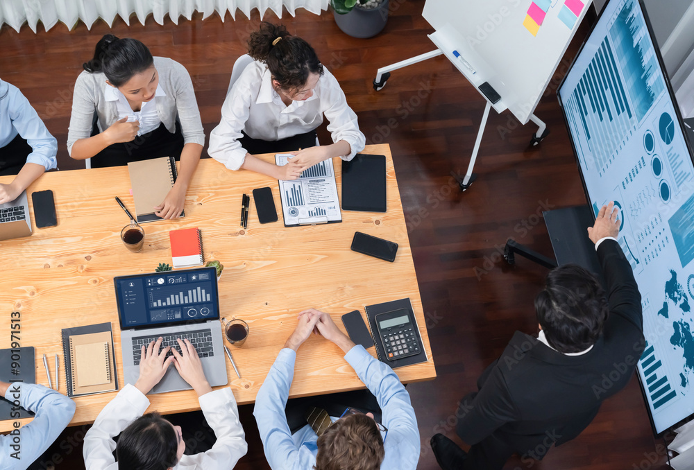 Obraz premium Wide top view of diverse group of business analyst team analyzing financial data report paper on meeting table. Chart and graph dashboard by business intelligence analysis. Meticulous