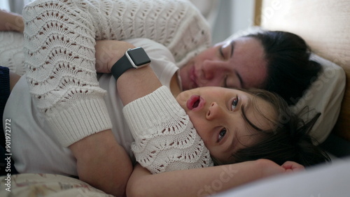 Cuadro en lienzo Mother and young boy lying in bed, with the mother peacefully asleep and the boy