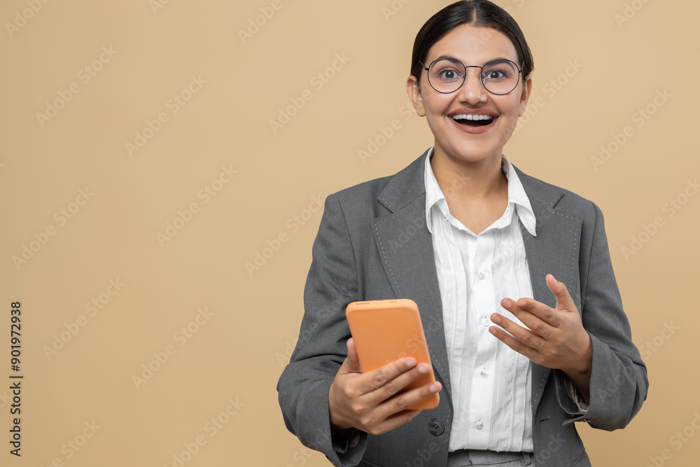 Amazed Indian woman in official style jacket using smart phone for reading breaking messages Amazed Indian woman in official style jacket using smart phone for reading breaking messages