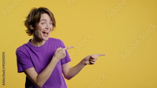 Happy promoter woman presenting on workspace, mockup, promo commercial isolated on yellow background. Portrait of american lady, pointing with arms on left with copy space. photo