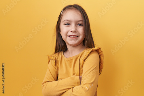Vászonkép Adorable hispanic girl, a picture of confidence and happiness, standing in front of a yellow isolated background