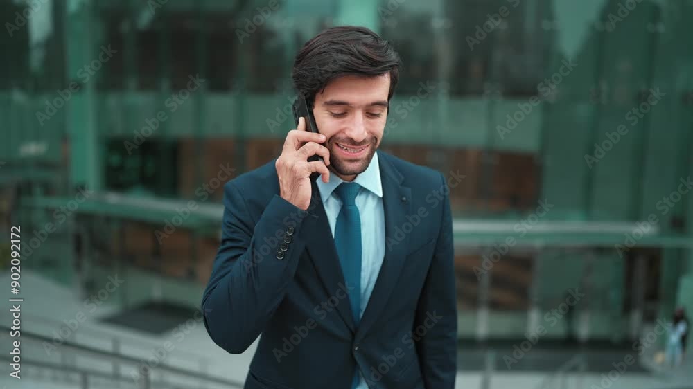 Skilled caucasian project manager calling phone while walking at city with blurred background. Skilled businessman using smart phone talking to project manager with blurred background. Exultant. Skilled caucasian project manager calling phone while walking at city with blurred background. Skilled businessman using smart phone talking to project manager with blurred background. Exultant.