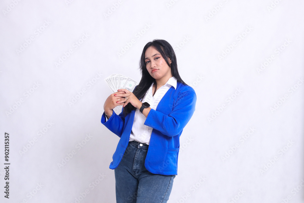 beautiful mature office woman wearing blue formal suit standing pouting to camera both hands holding dollar bill to right isolated white background. for transaction, finance, business content beautiful mature office woman wearing blue formal suit standing pouting to camera both hands holding dollar bill to right isolated white background. for transaction, finance, business content