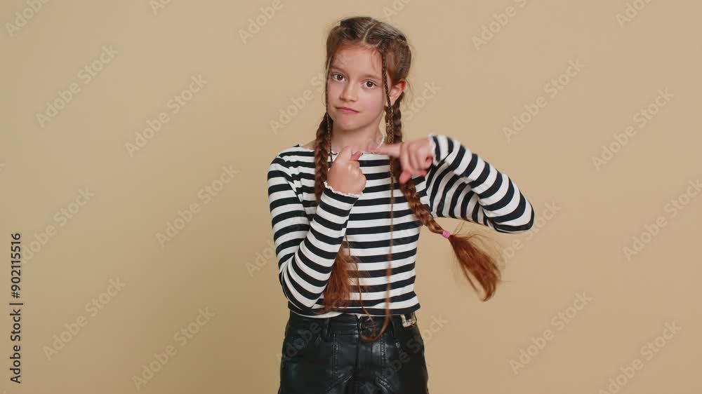 Angry preteen child girl kid showing fig negative gesture, you don't get it anyway. Rapacious, avaricious, acquisitive. Body language. Refusal fig sign. Teenager children isolated on beige background Angry preteen child girl kid showing fig negative gesture, you don't get it anyway. Rapacious, avaricious, acquisitive. Body language. Refusal fig sign. Teenager children isolated on beige background