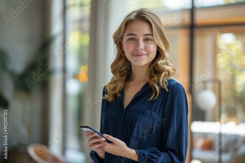 Young Woman in Casual Shirt Smiling and Holding Smartphone