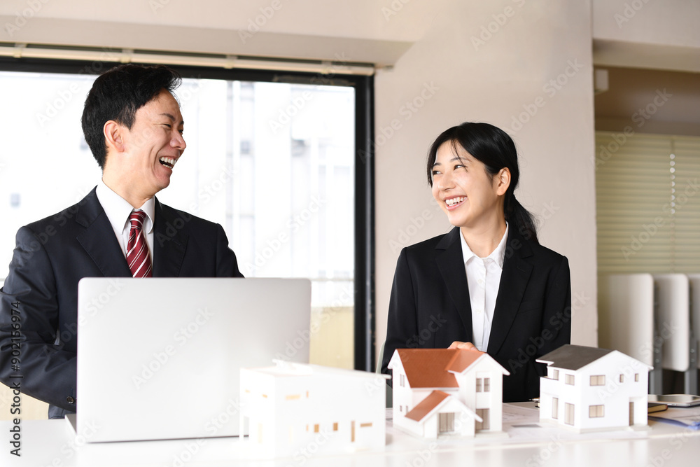 建築模型の前で会話する男女のビジネスパーソン 建築模型の前で会話する男女のビジネスパーソン