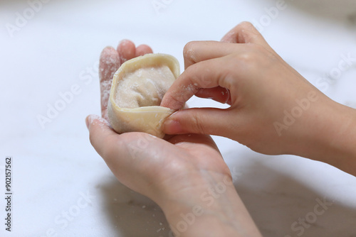 Close-up of a female's hand making kimchi dumpling with fingers, South Korea
 photo