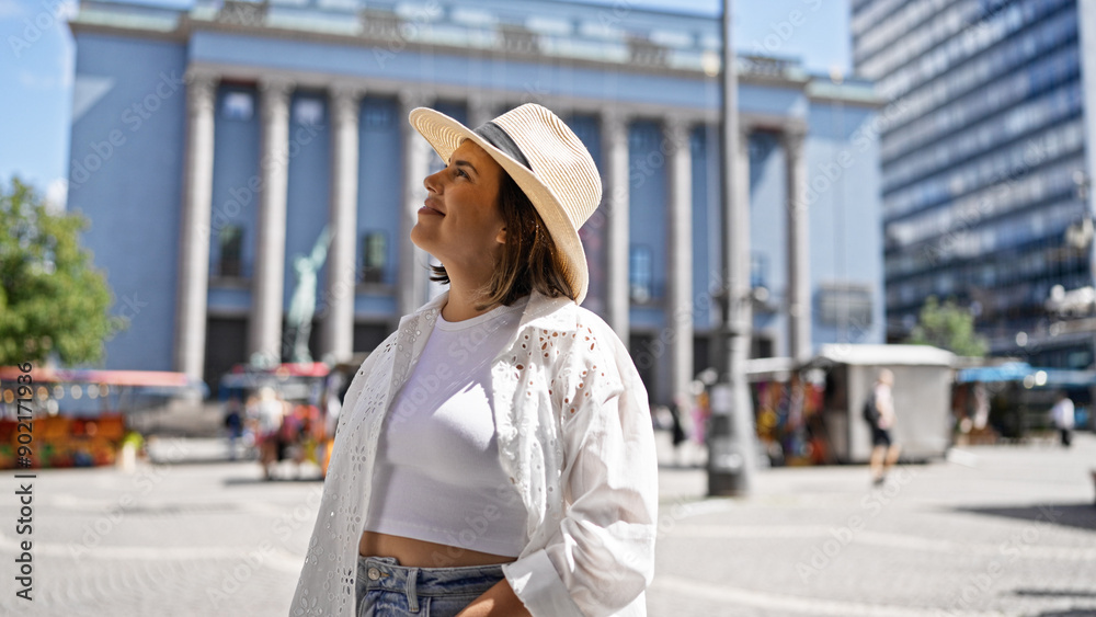 Beautiful young hispanic woman smiling confident looking to the side wearing summer hat at Nobel prize building Beautiful young hispanic woman smiling confident looking to the side wearing summer hat at Nobel prize building