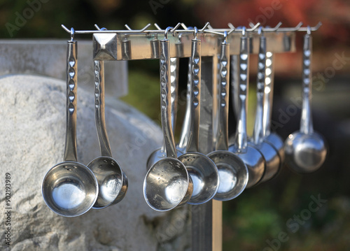 Close-up of stainless bowls hanging at the spring water site of Magoksa Temple near Gongju-si, South Korea
 photo