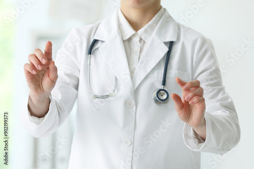 Doctor with stethoscope holding something in clinic, closeup