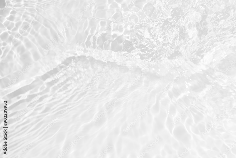 Obraz premium White water with ripples on the surface. Defocus blurred transparent white colored clear calm water surface texture with splashes and bubbles. Water waves with shining pattern texture background.