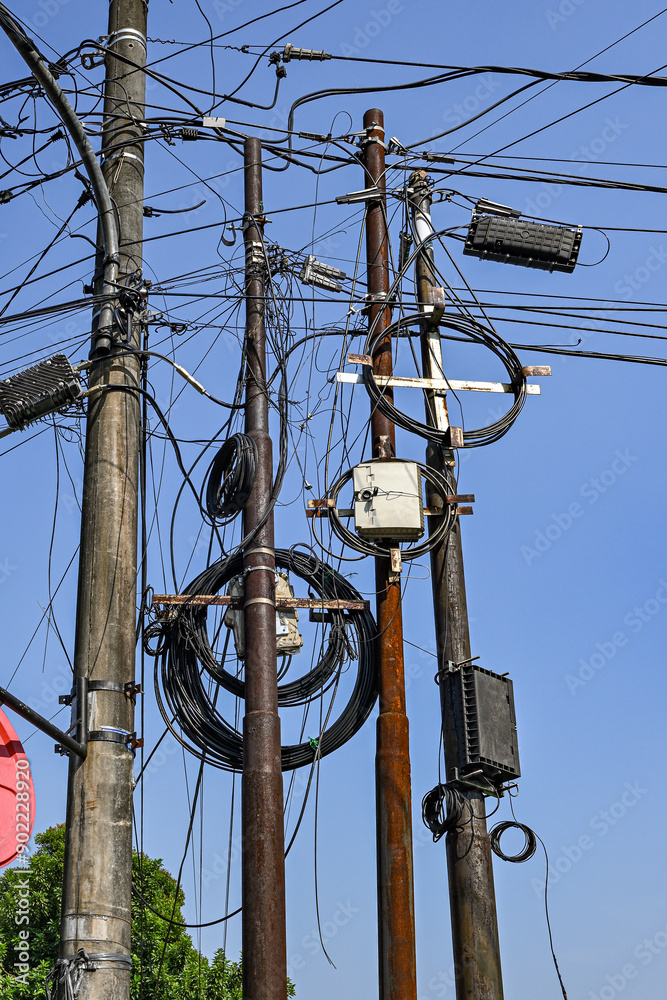 A bunch of power lines are tangled together and the sky is blue A bunch of power lines are tangled together and the sky is blue