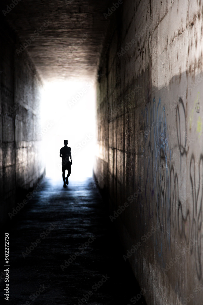 Mysterious tunnel with human figure walking toward the light. Mysterious tunnel with human figure walking toward the light.