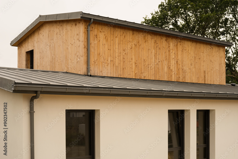 Modern architecture single-family house with flat roof made of metal titanium zinc and cladding made of untreated natural larch wood Modern architecture single-family house with flat roof made of metal titanium zinc and cladding made of untreated natural larch wood