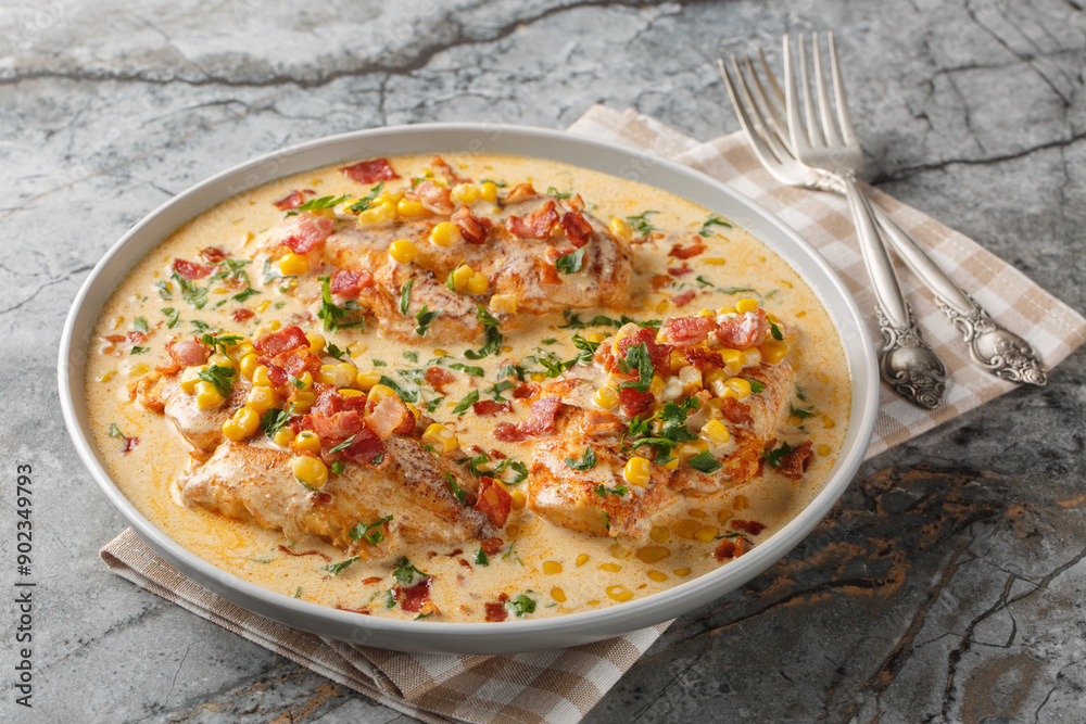 Pan-seared chicken in a creamy, spicy, street corn sauce with bacon closeup on the plate on the table. Horizontal Pan-seared chicken in a creamy, spicy, street corn sauce with bacon closeup on the plate on the table. Horizontal