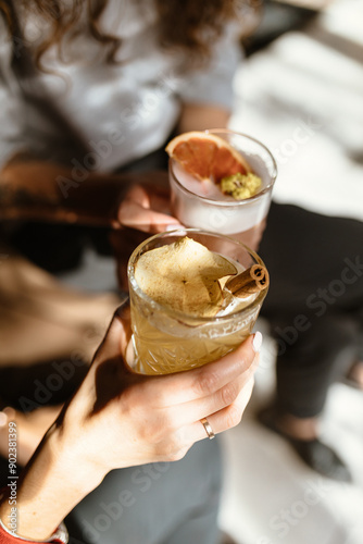 Two cute girls are drinking refreshing cocktails in a beautiful bar