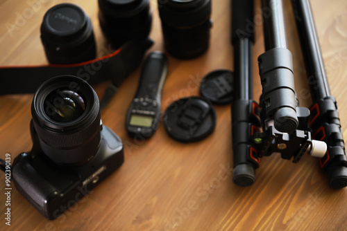 Professional Photography Equipment: DSLR Camera, Lenses, Tripod, and Accessories on Wooden Surface