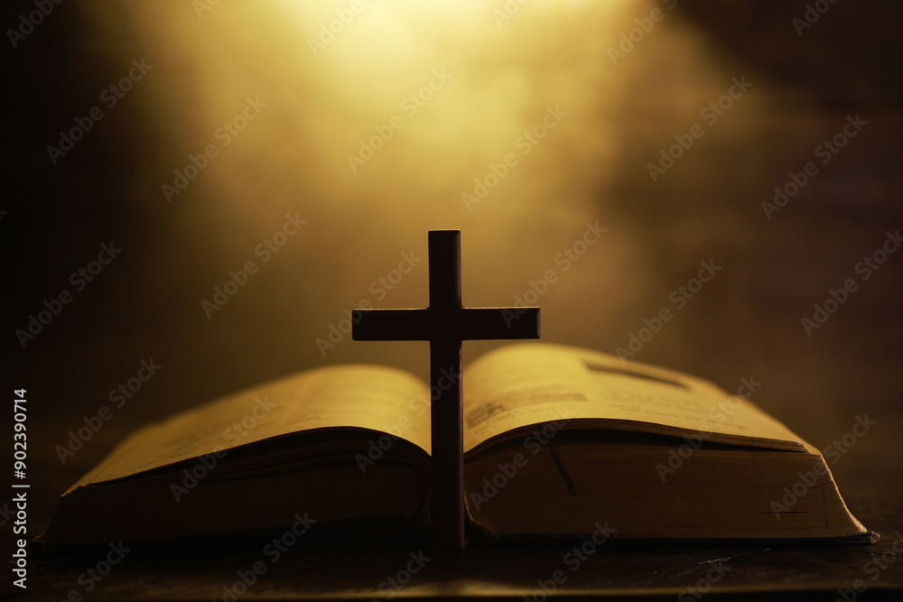 Illuminated Bible and Cross Silhouette Against Dramatic Golden Background Illuminated Bible and Cross Silhouette Against Dramatic Golden Background