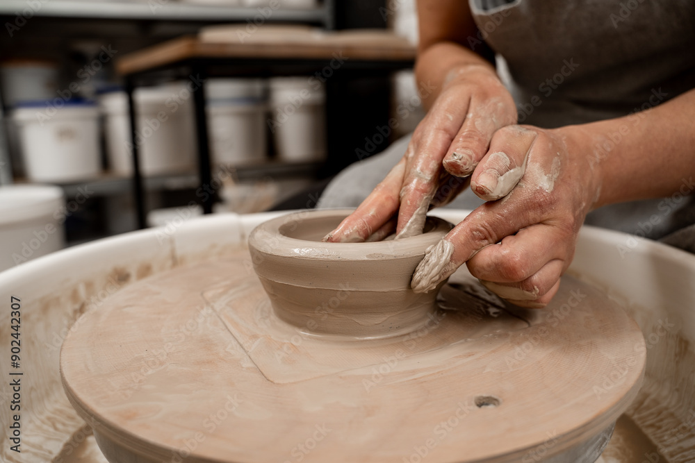 Creating a ceramic bowl by yourself in a pottery class. Wheel throwing. Learning how to model clay into different shapes with pottery wheel. Creating a ceramic bowl by yourself in a pottery class. Wheel throwing. Learning how to model clay into different shapes with pottery wheel.