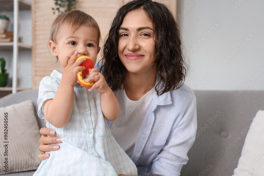 Mother and her little baby with nibbler eating food on sofa at home Mother and her little baby with nibbler eating food on sofa at home