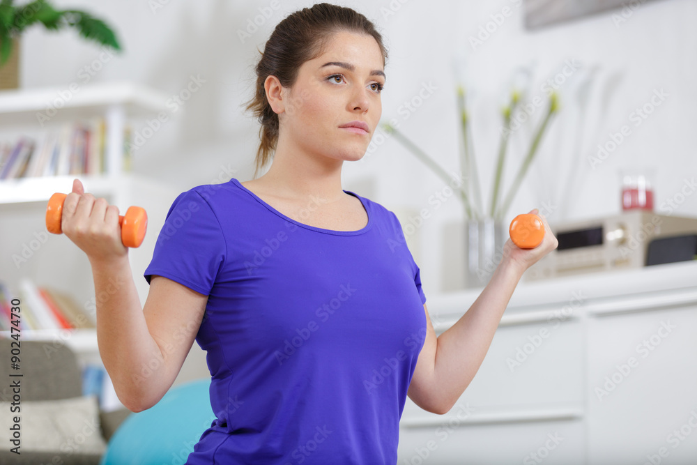 beautiful young woman at home exercising with dumbbells beautiful young woman at home exercising with dumbbells