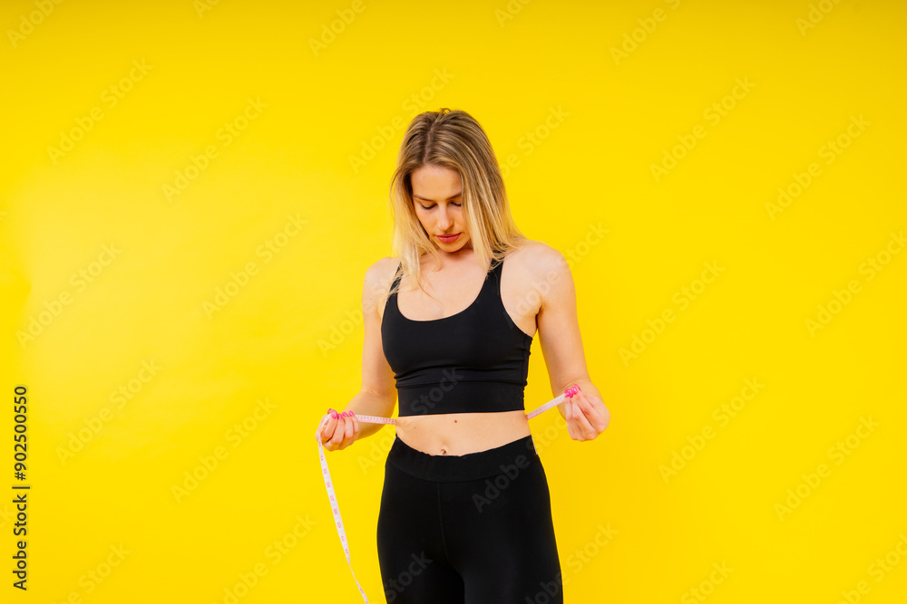 A weight loss and healthy lifestyle concept. Smiling slim woman measuring her waist with tape A weight loss and healthy lifestyle concept. Smiling slim woman measuring her waist with tape