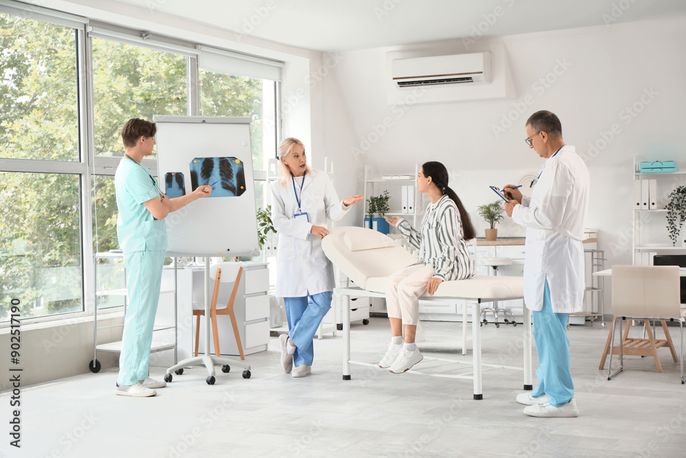 Obraz premium Doctors studying patient's x-ray image of lungs in clinic