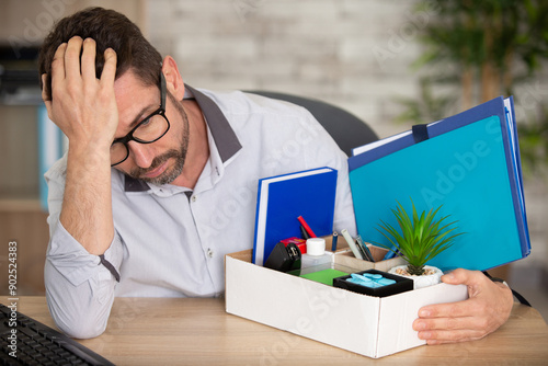 fired male employee holding box of belongings