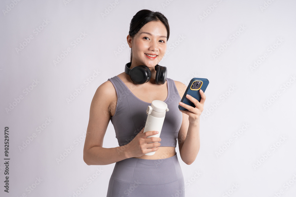 Portrait of Asian woman wearing sportswear, posing on white background