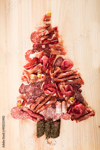 Fotografie Christmas tree made of sausage on a background of a wooden wall