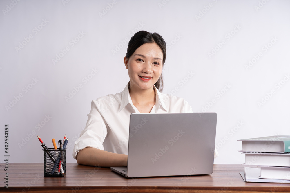 Young female businessman sitting at desk on white background Young female businessman sitting at desk on white background
