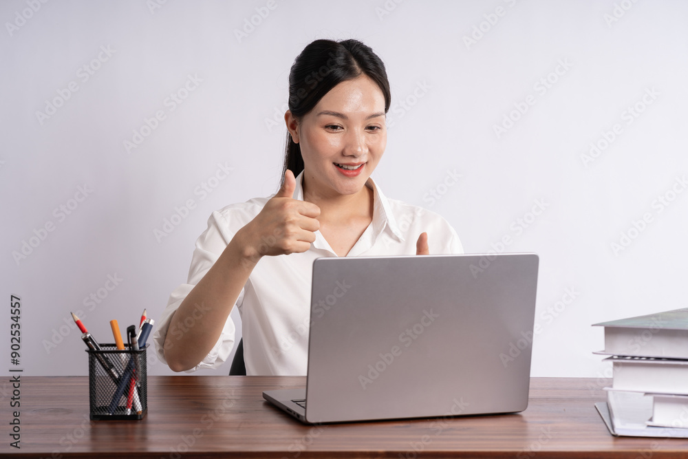 Young female businessman sitting at desk on white background Young female businessman sitting at desk on white background