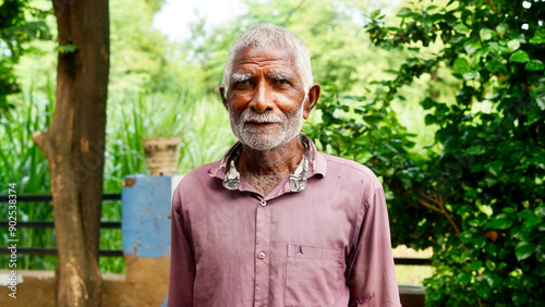 Happy Old Indian senior citizen. Portrait of a rural Indian farmer posing at white background.