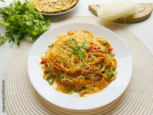 Bihun goreng, bee hoon goreng or mee hoon goreng refers to a dish of fried noodles cooked with rice vermicelli in both the Indonesian and Malay. Cooked with vegetables photo