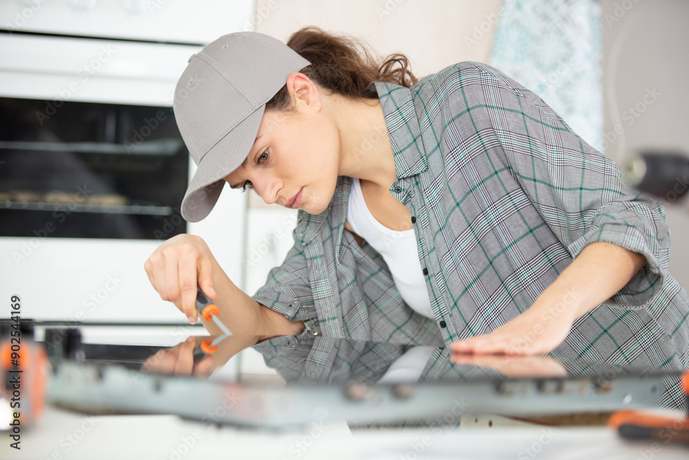 woman working on a new kitchen installation woman working on a new kitchen installation