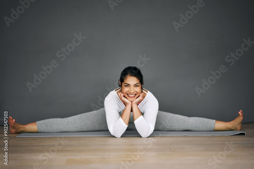 Woman, yoga and house portrait in splits, pilates and wall background for body wellness with relaxing smile. Happy, flexibility training and stretching legs on mat, contortion and balance activity