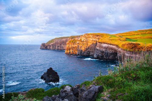 Atlantic ocean coastline of São Miguel Island, Azores, Portugal. Stones, rocks and water at sunset. Nature, landscape photography. Golden hour.