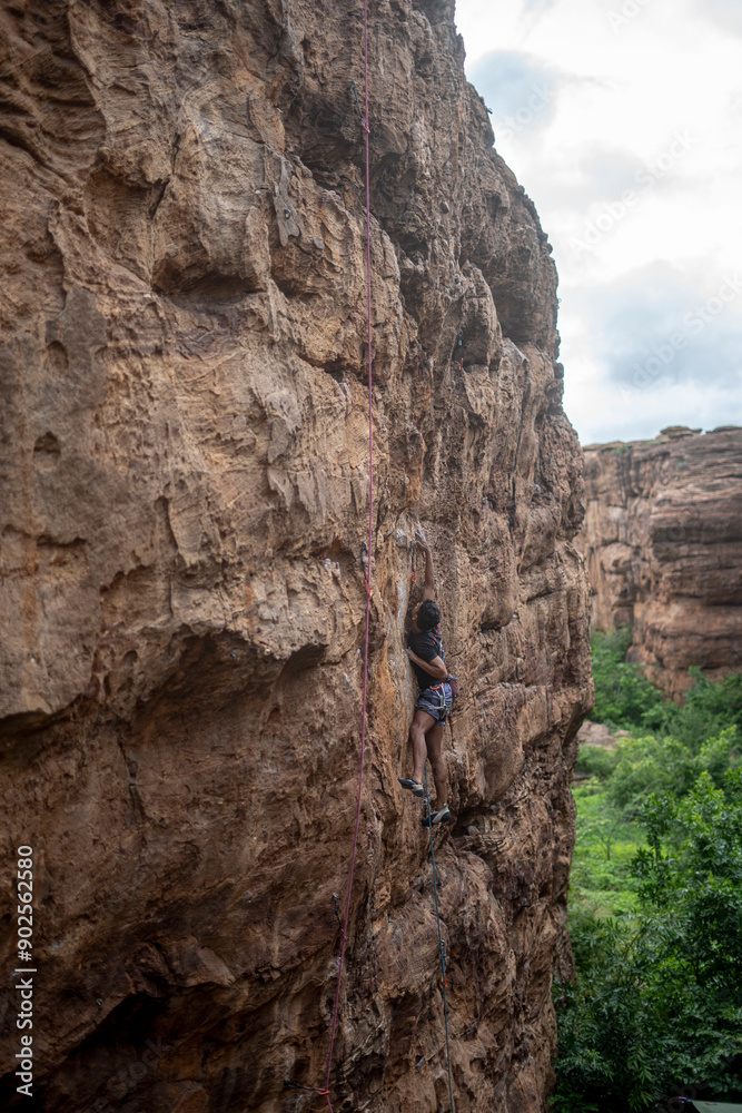 A climber trying to move on a climbing wall in Badami, Karnataka. A climber trying to move on a climbing wall in Badami, Karnataka.