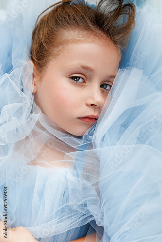 Top view of close-up portrait of a charming little girl in a blue tulle dress