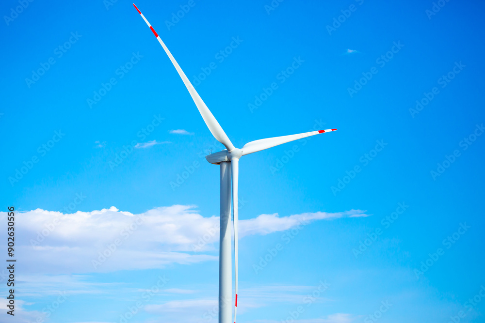 Fleet of power generators in motion. The blades of the wind farm rotate against the sky. The concept of extracting electricity from renewable sources. Wind turbine to generate electricity. Fleet of power generators in motion. The blades of the wind farm rotate against the sky. The concept of extracting electricity from renewable sources. Wind turbine to generate electricity.