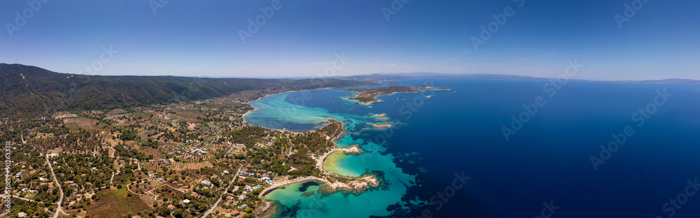Panoramic aerial view of the stunning coastline of Sithonia, Diaporos island, Greece, with turquoise bays, lush greenery, and scattered islands in the deep blue sea, capturing the breathtaking beauty