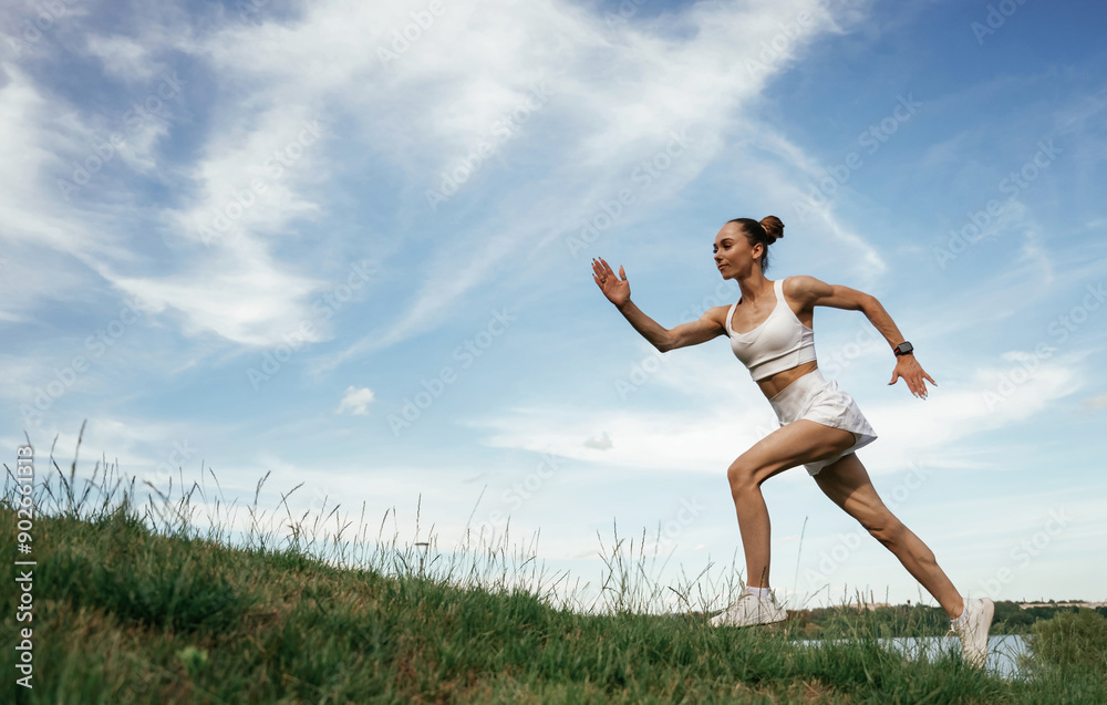 Beautiful sky at background. Young skinny fitness woman is outdoors Beautiful sky at background. Young skinny fitness woman is outdoors