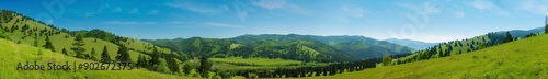 panoramic photo of beautiful green mountains and forests, grassy hills, clear blue sky