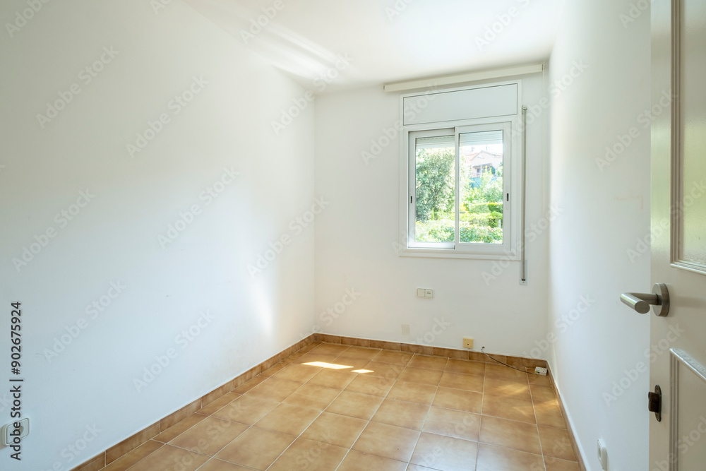 A compact, bright room featuring a sizable window allowing abundant natural light, adorned with tiles on the floor, presenting a peaceful and inviting atmosphere. A compact, bright room featuring a sizable window allowing abundant natural light, adorned with tiles on the floor, presenting a peaceful and inviting atmosphere.
