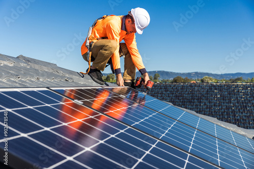 Solar panel technician with drill installing solar panels