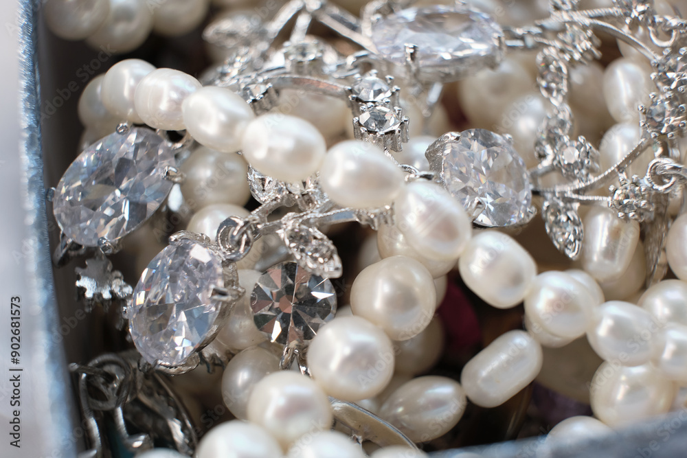 Close-up of an elegant assortment of jewelry, including pearl necklaces and silver diamond-studded pieces. This image captures the luxury and intricacy of fine jewelry, showcasing the beauty and Close-up of an elegant assortment of jewelry, including pearl necklaces and silver diamond-studded pieces. This image captures the luxury and intricacy of fine jewelry, showcasing the beauty and